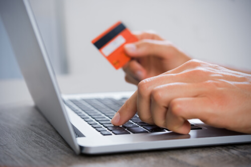 Homeowner on their laptop with a credit card in hand