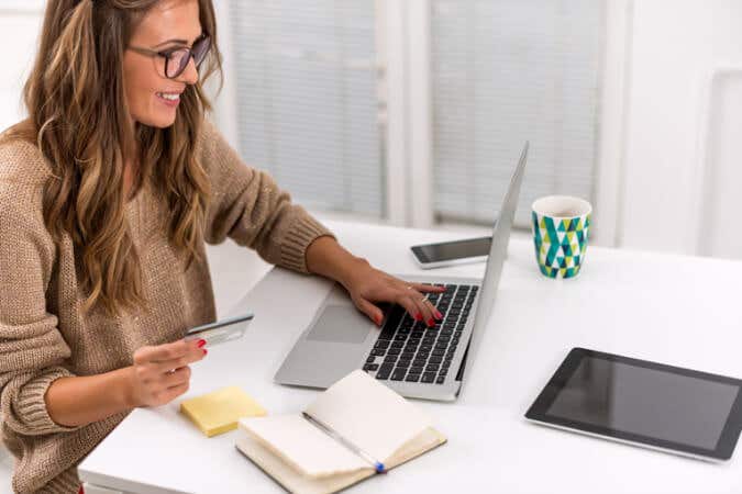 Homeowner making an online purchase with card in her hand