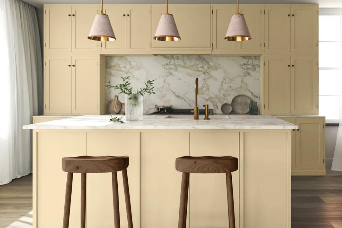 Light creamy yellow kitchen design with marble backsplash and countertop