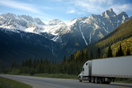 Freight truck driving across country through the mountains