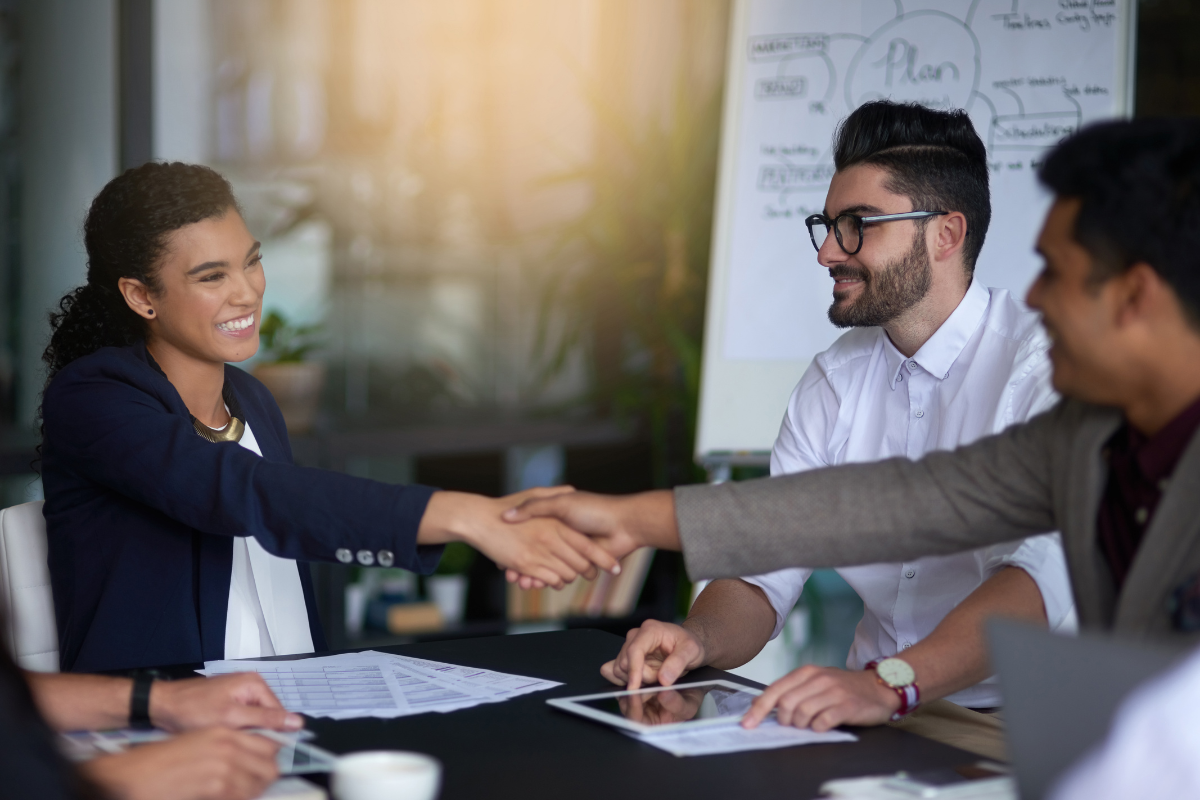 Group of professionals shaking hands across the table