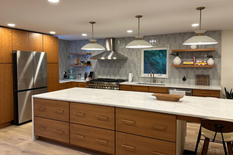 Mid-century modern kitchen design with medium wood slab cabinets and white quartz countertops