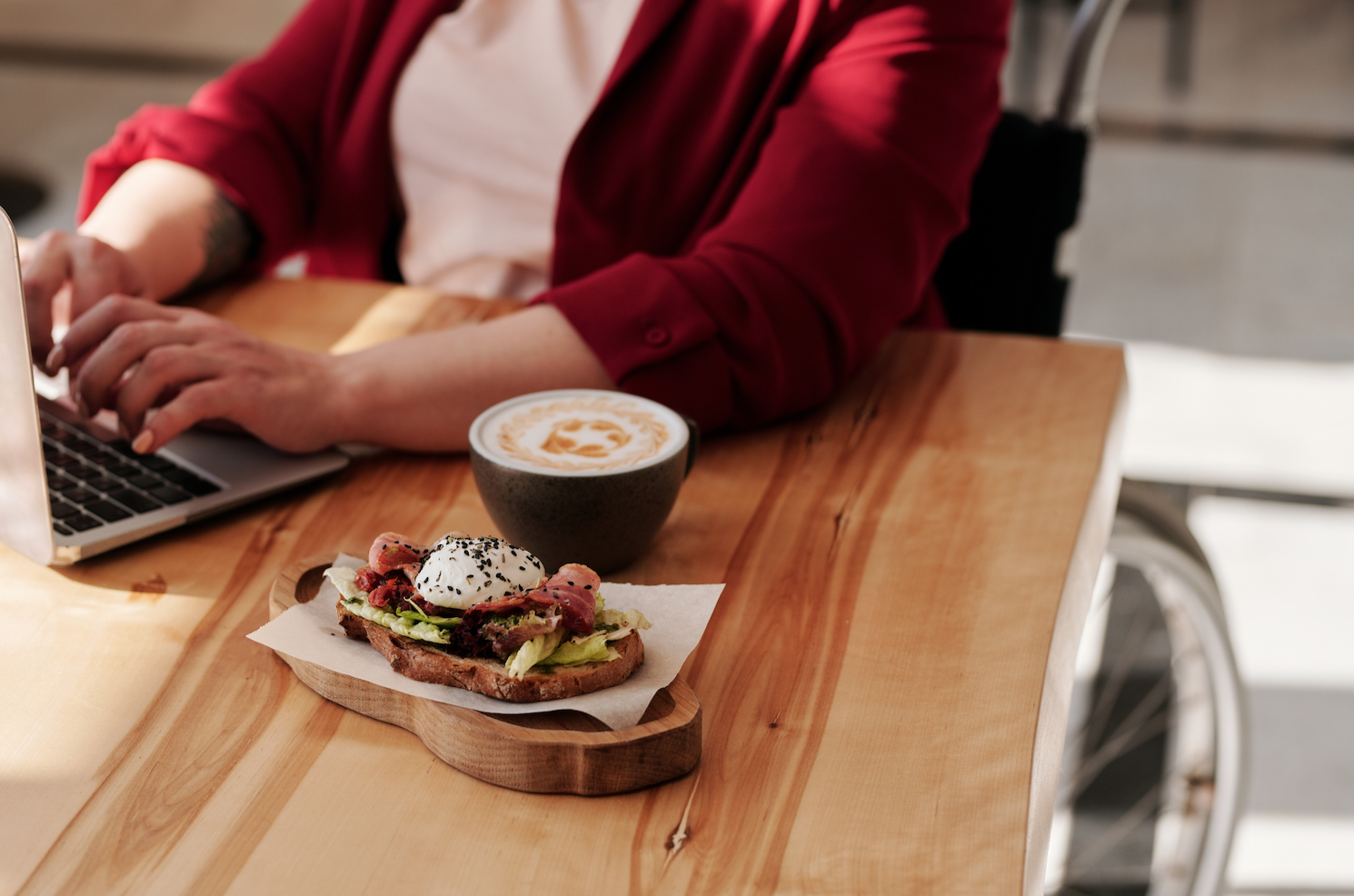 Homeowner typing at kitchen table with dinner in a wheelchair