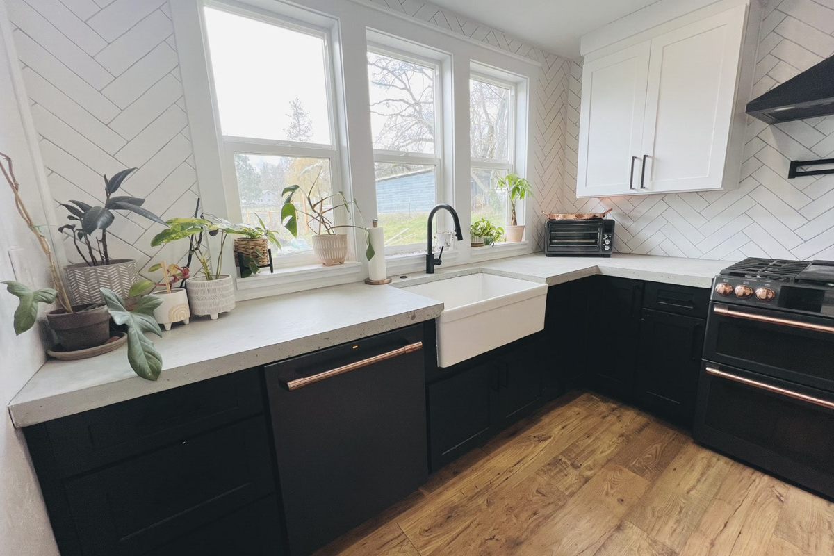 Modern white and black shaker kitchen design with white quartz countertops and black and gold appliances