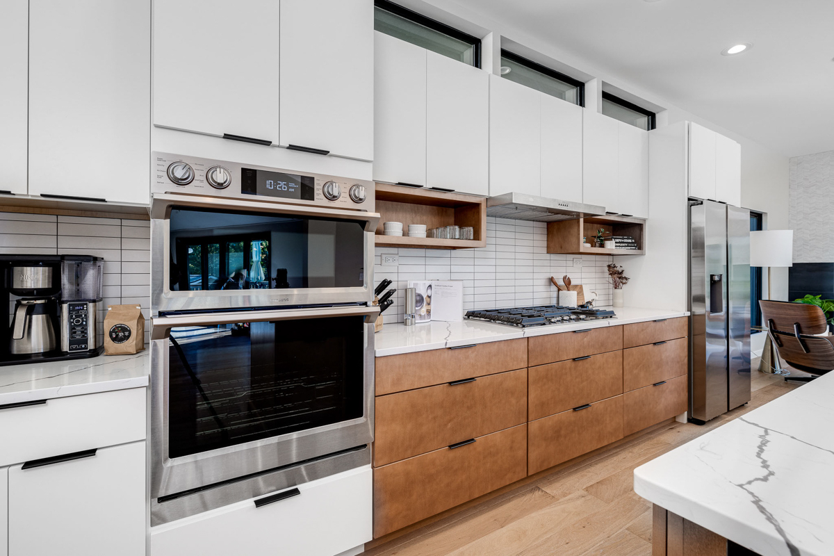 Mid-century modern kitchen design with white slab cabinets along one wall with warm wood base cabinets and accents plus a warm wood kitchen island and white quartz countertops