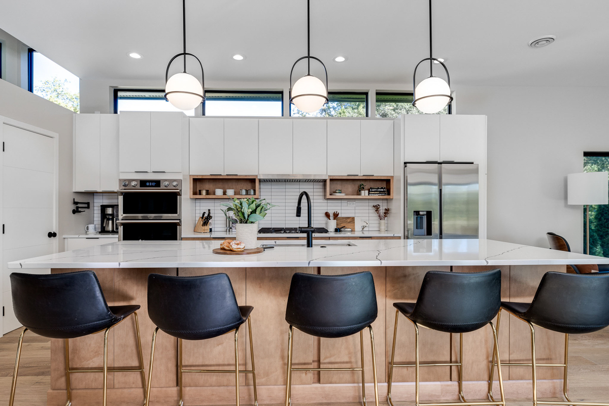 Mid-century modern kitchen design with white slab cabinets along one wall with warm wood base cabinets and accents plus a warm wood kitchen island and white quartz countertops