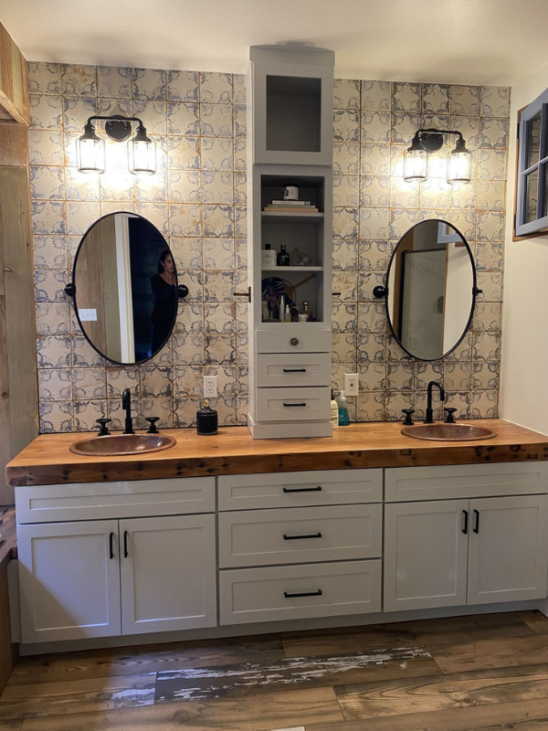 Farmhouse double vanity with soft gray shaker bathroom cabinets, a butcher block countertop, and tall wall cabinet in the center