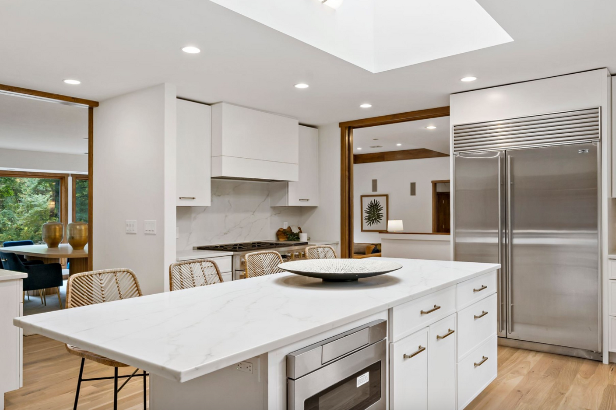 L-shaped white skinny shaker kitchen design with a kitchen island and white marble countertops