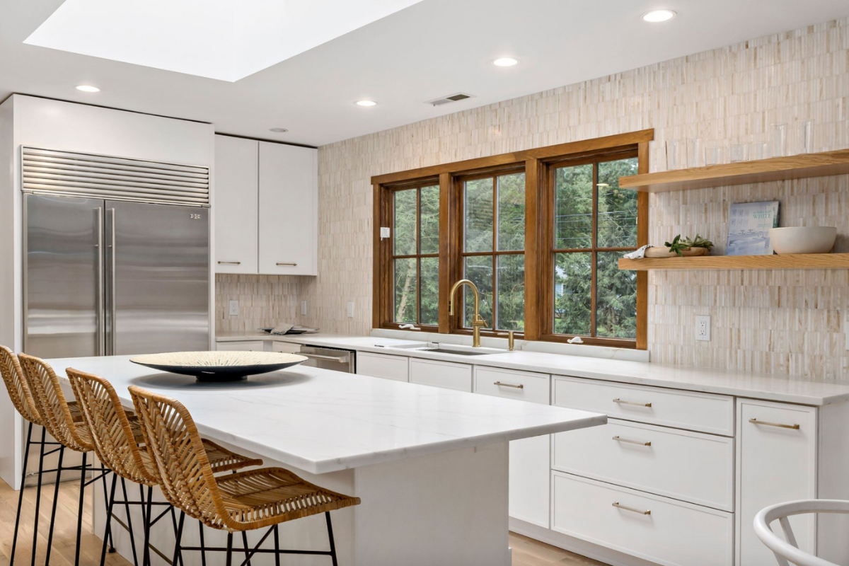 L-shaped white skinny shaker kitchen design with a kitchen island and white marble countertops