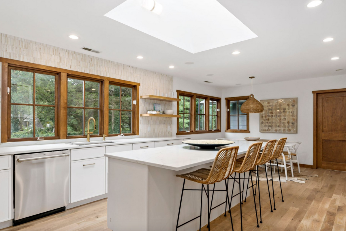 L-shaped white skinny shaker kitchen design with a kitchen island and white marble countertops