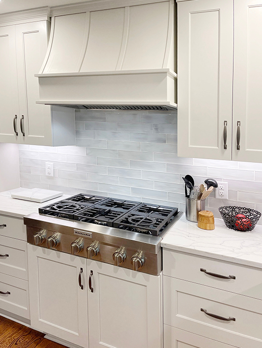 Cream shaker kitchen with sloped wood kitchen hood and wood strapping