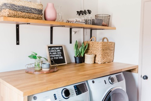 Small laundry room with butcher block countertops over washing machines 