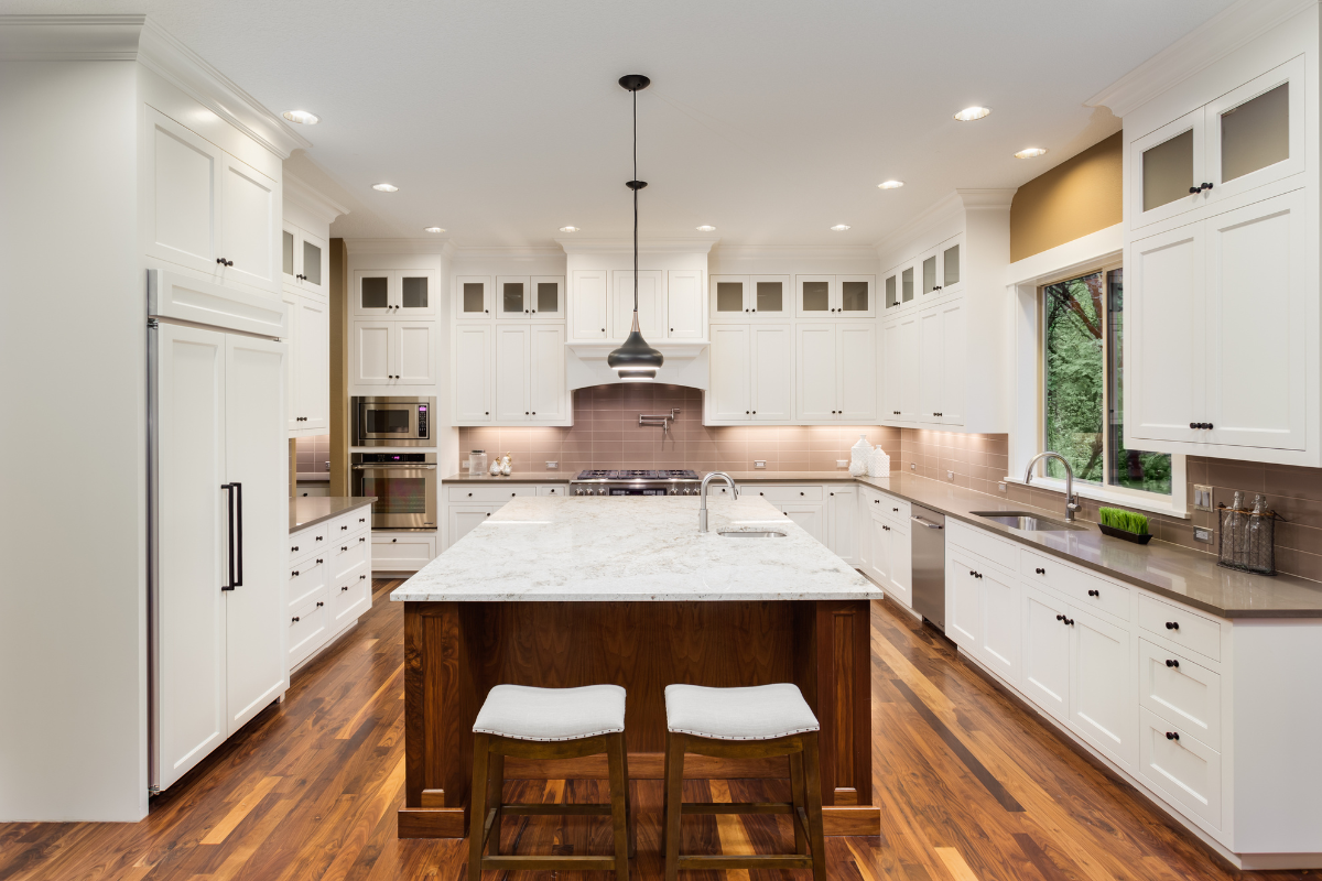Stacked white shaker kitchen design with glass and a wood island and white stone countertops Stacked white shaker kitchen design with glass and an island