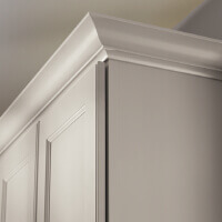 Decorative white kitchen cabinets with transitional curvy crown molding above. 