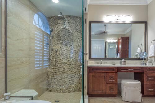 Traditional bathroom with red-stained vanity and glass walk-in shower