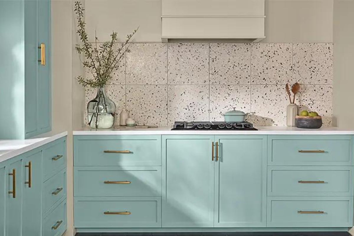 Light aqua blue kitchen cabinet design with a white terrazzo backsplash and white kitchen hood