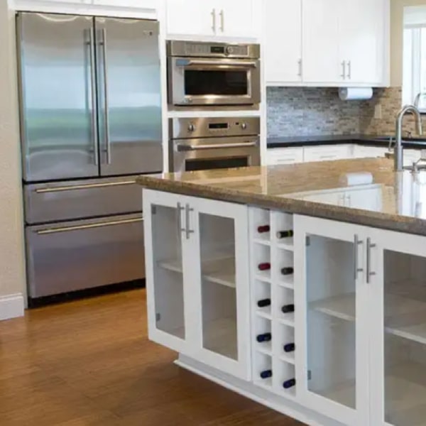 White shaker island with two wine cubes and glass door base cabinets