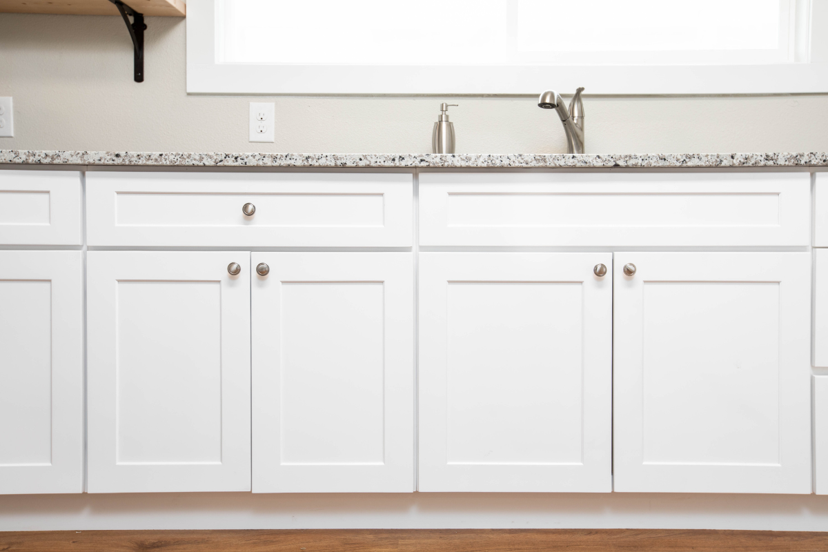 White shaker base cabinets and sink base with brushed nickel hardware