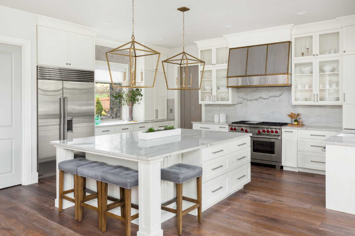 Large U-shaped white shaker kitchen design with island and white marble countertops and backsplash