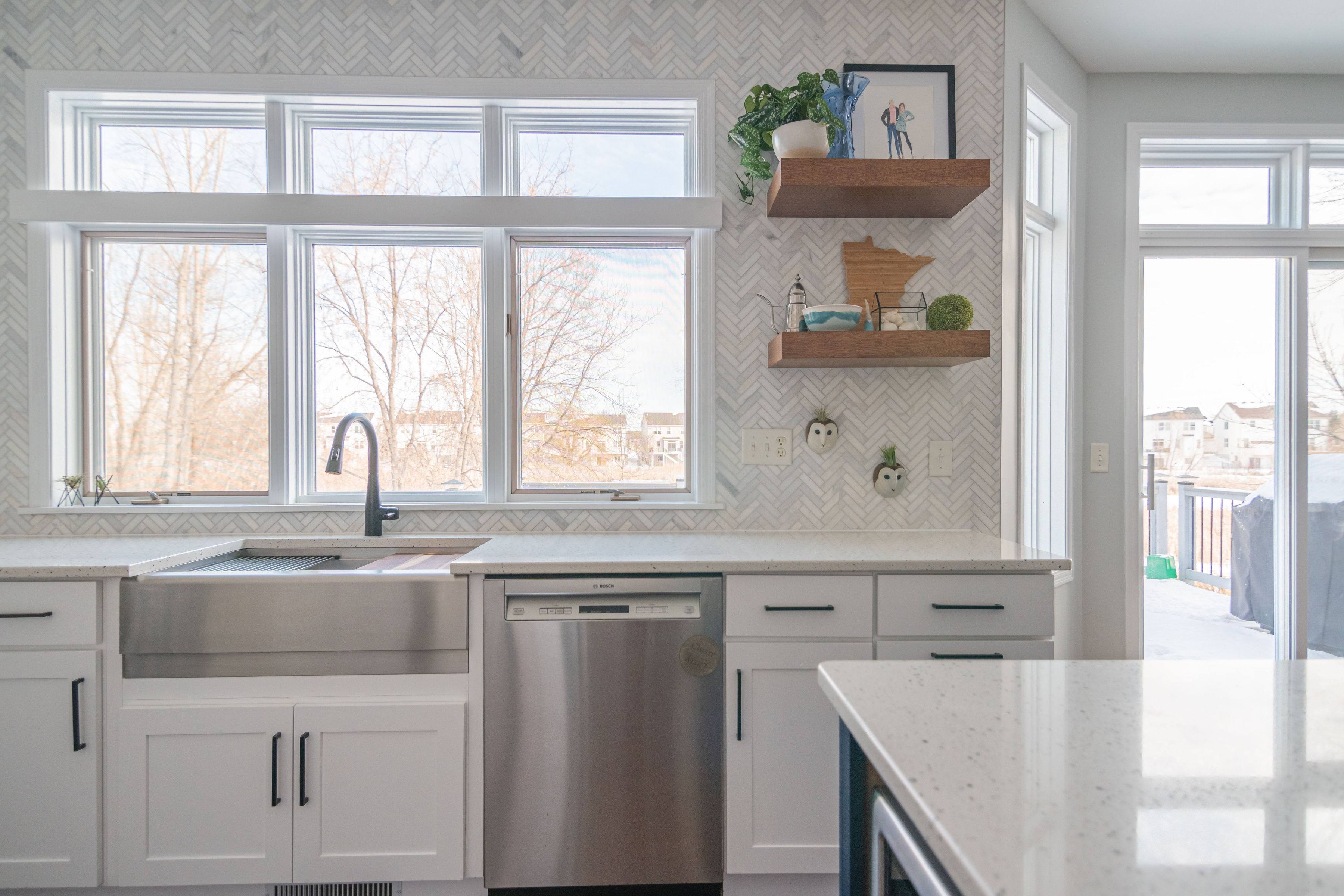 CliqStudios project: White shaker kitchen cabinets and wood floating shelves on marble herringbone tile