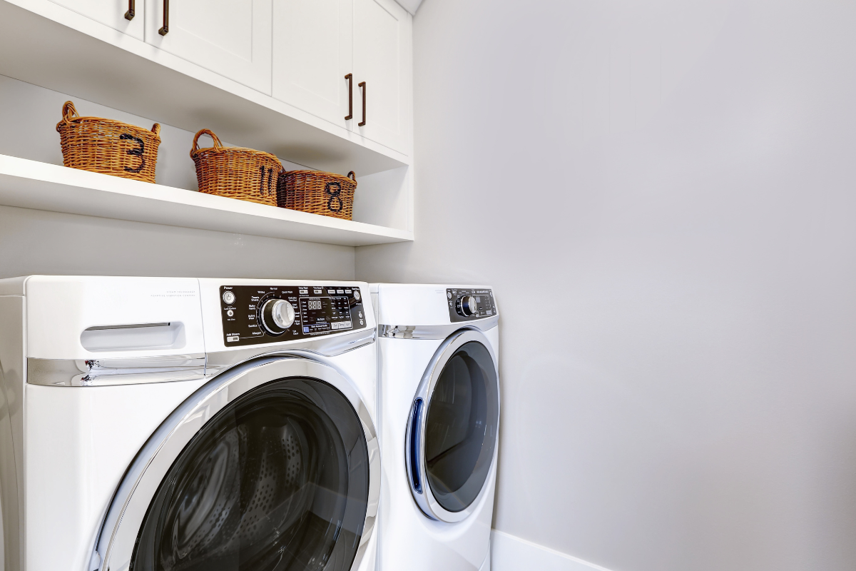 White shaker laundry room cabinets with built-in shelves