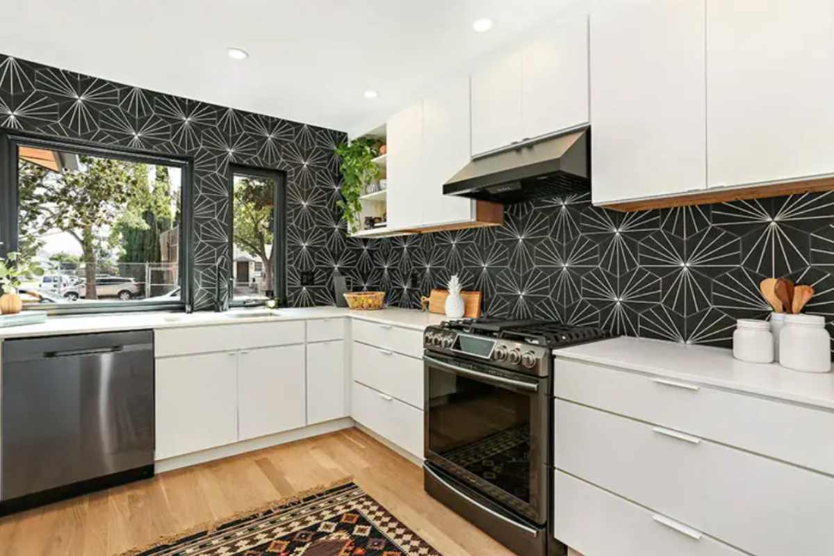 White slab kitchen cabinets with a black and white retro star backsplash