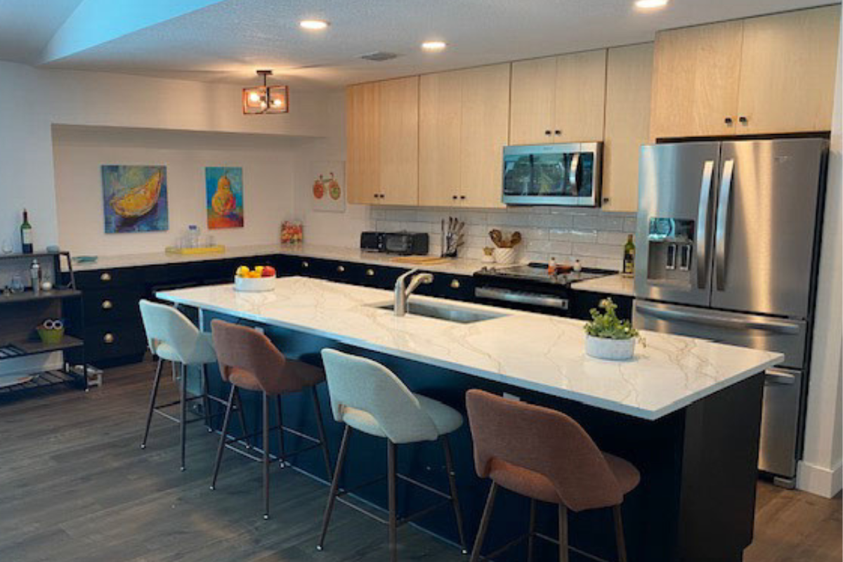 Contemporary slab kitchen design with black base cabinets and natural maple wall cabinets