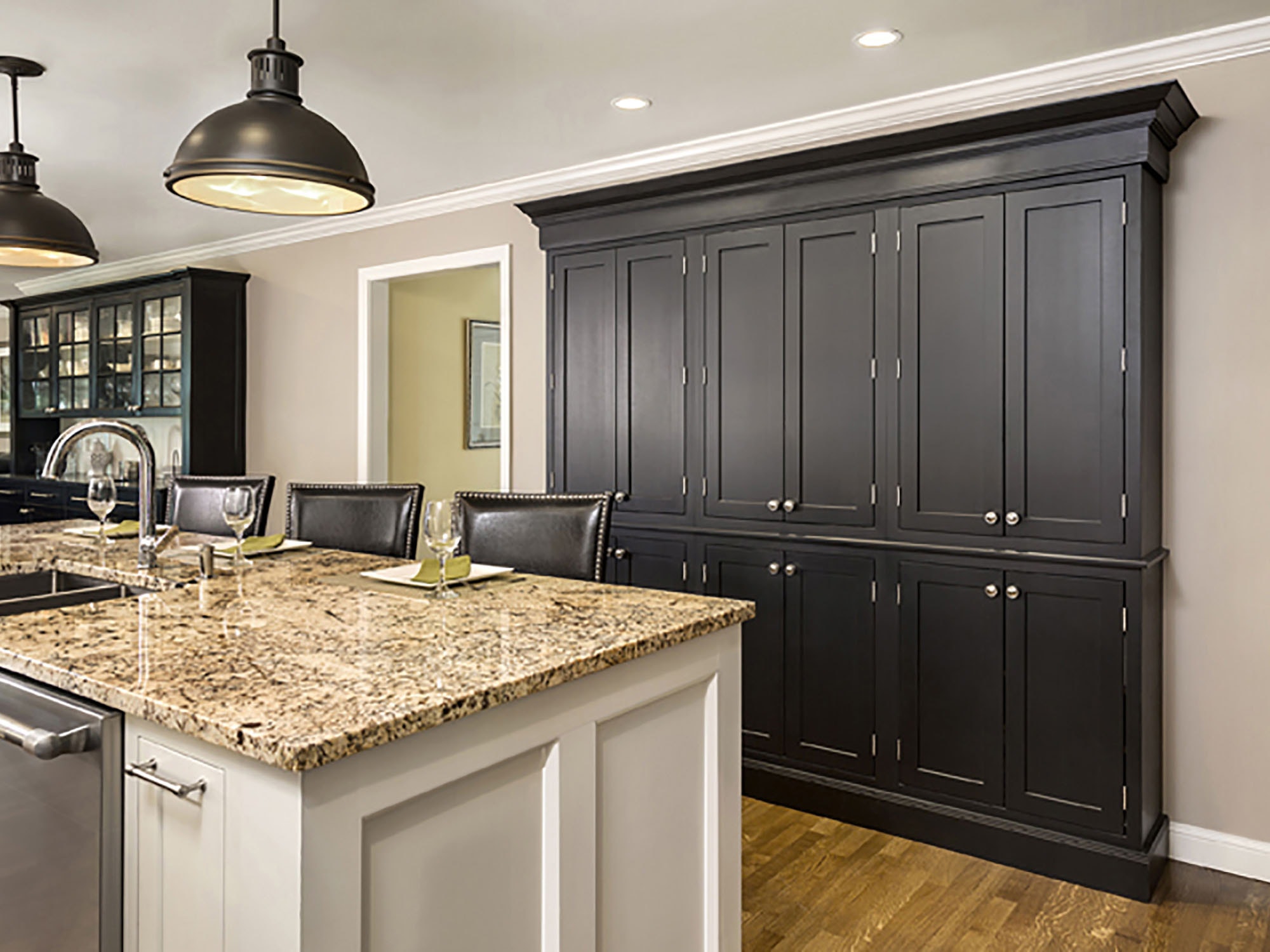 built in pantry wall built of black shaker cabinets with tall crown molding