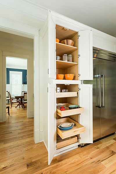 Pull-out storage cabinet with three shelves storing spices