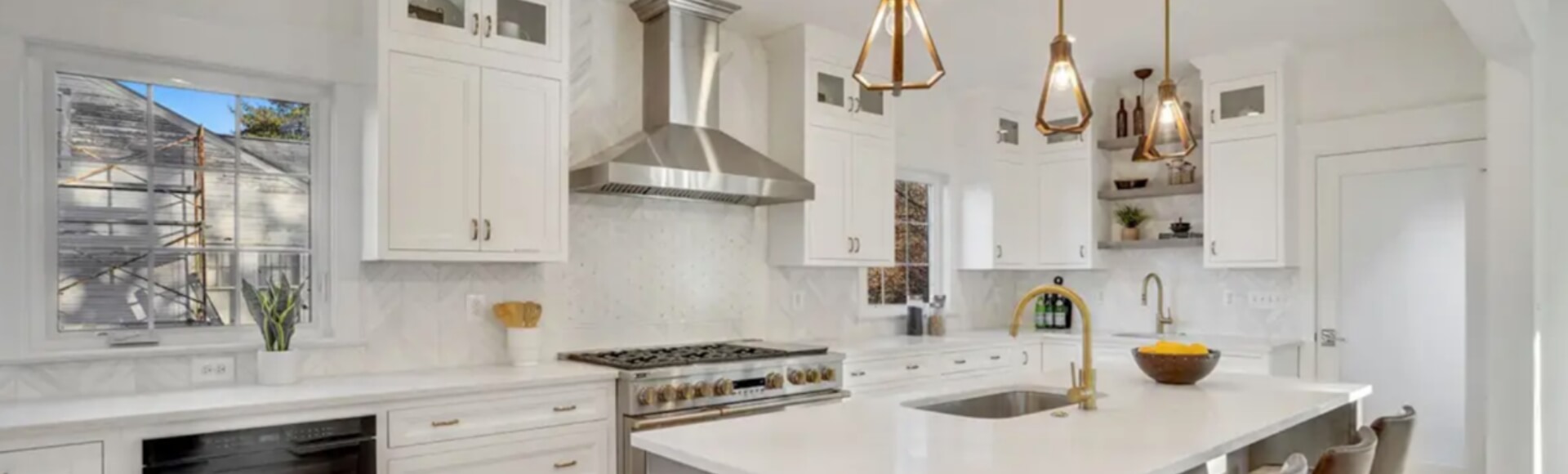 Stacked white inset kitchen cabinets with a large gray island