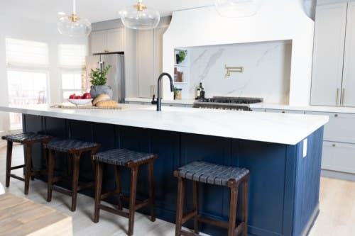 Chic shaker gray kitchen cabinet design with a large navy blue island and white quartz countertops