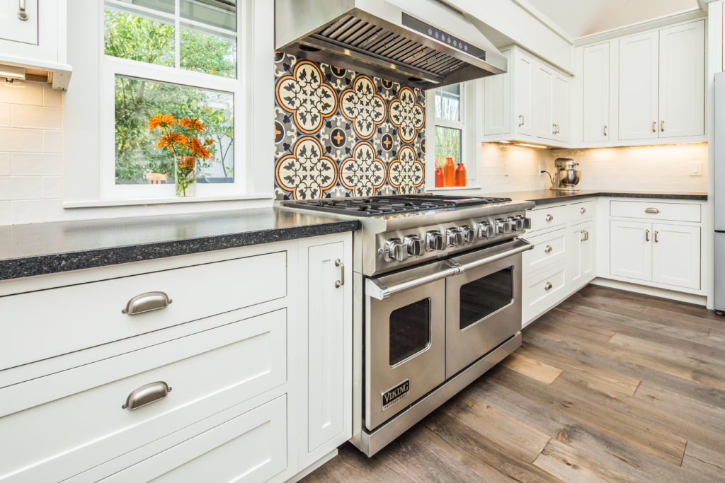 Inset white shaker kitchen cabinets with a large stainless steel chef's range 