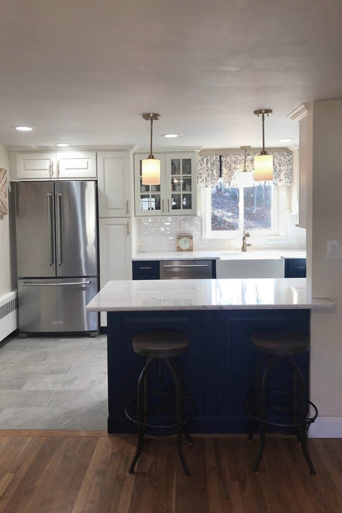 Small blue and white galley kitchen with peninsula cabinets