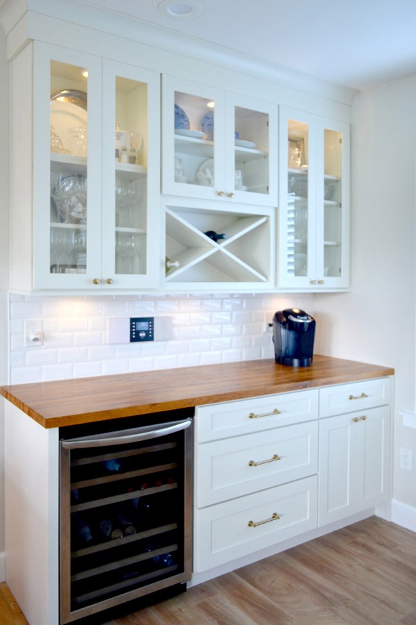 CliqStudios Shaker cabinets in White used in a butler's pantry, complete with a wine cooler and rack, a butcher block counter, and glass cabinets.