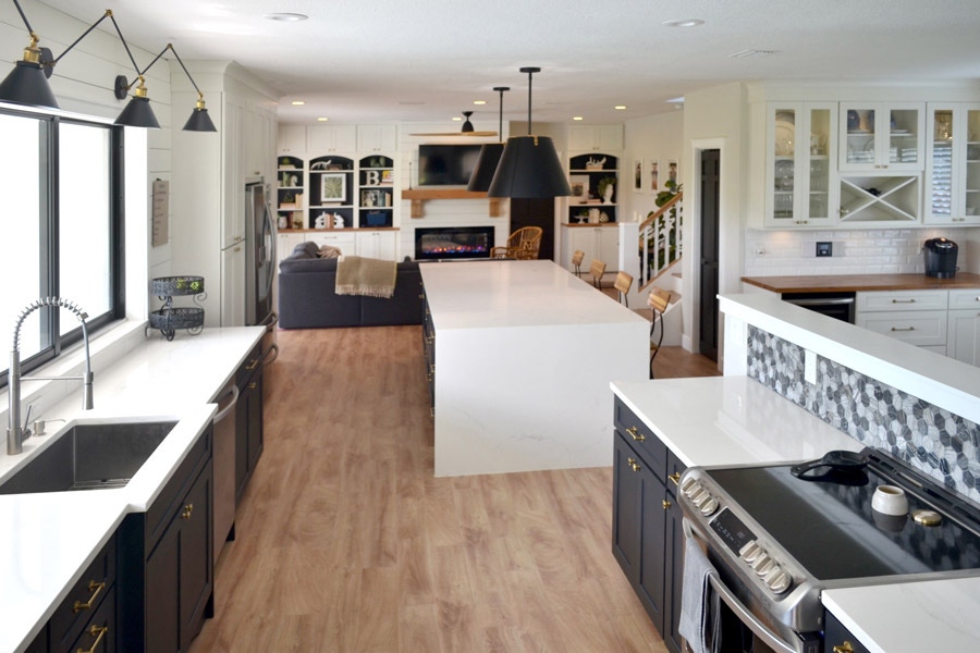 Full view of a two-toned kitchen using CliqStudios Shaker cabinets in Black and White. The countertops are white and butcherblock.