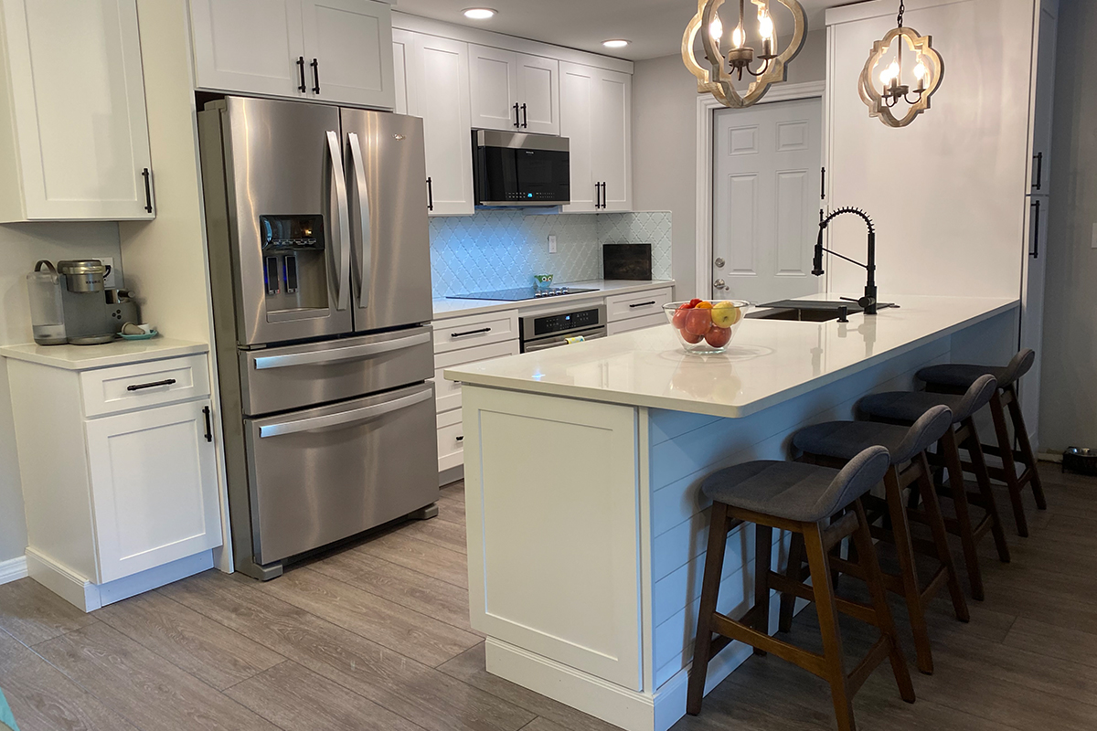 CliqStudios project: One-wall white shaker kitchen cabinets with shiplap island and rustic pendant lighting