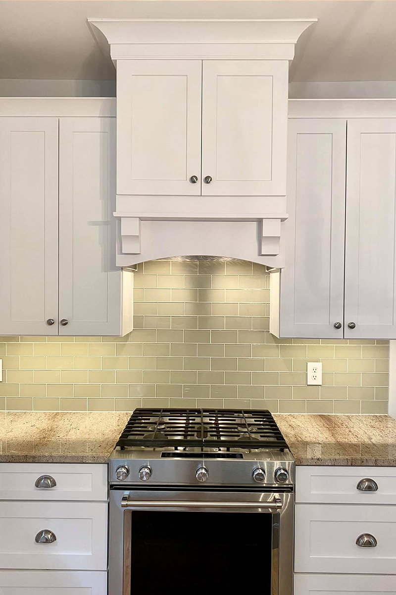 White double-door wood hood in shaker style with arched cabinet valance at the bottom