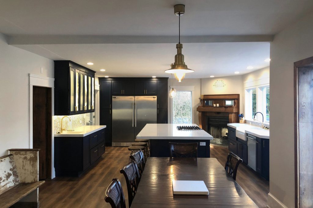 Large blue and white kitchen with wet bar, island, and sink under window