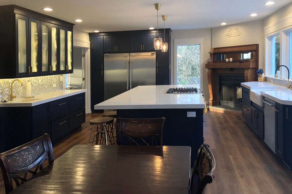 Dining room opens to a large kitchen with blue cabinets, island and large windows