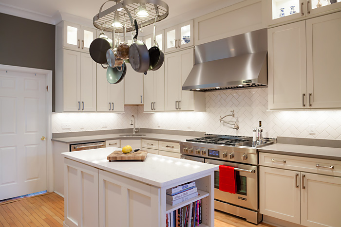 long kitchen with white cabinets and professional range