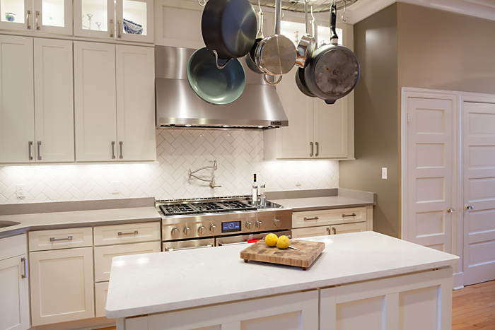 white shaker cabinets in remodeled dc home complement the home's original painted white wooden doors, with five recessed flat panels each