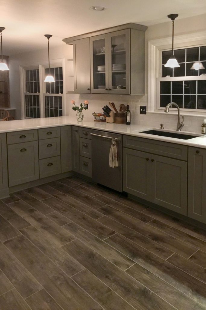 Gray kitchen cabinets and pull-out storage surround the kitchen sink