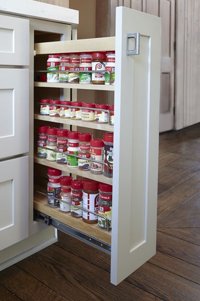 Pull-out storage cabinet with three shelves storing spices