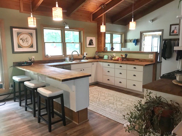 CliqStudios project: U-shaped white base kitchen cabinets with exposed wood beams above