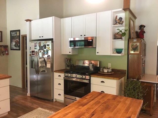 CliqStudios project: U-shaped white base kitchen cabinets with exposed wood beams above