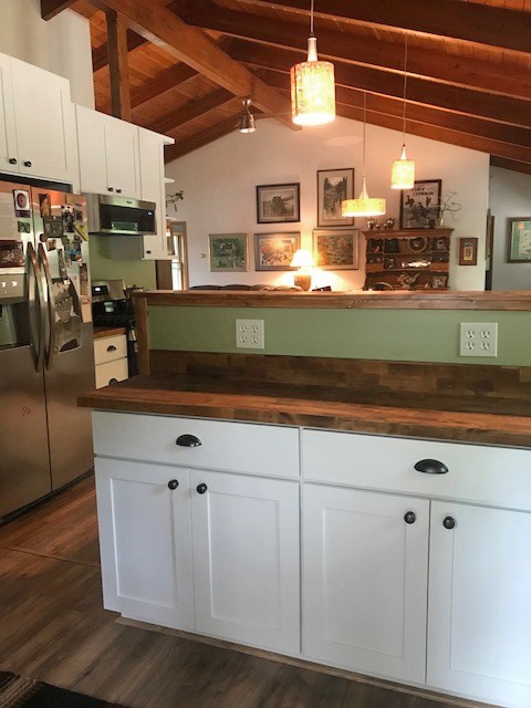 CliqStudios project: U-shaped white base kitchen cabinets with exposed wood beams above