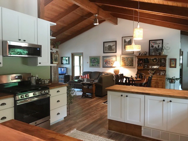 CliqStudios project: U-shaped white base kitchen cabinets with exposed wood beams above