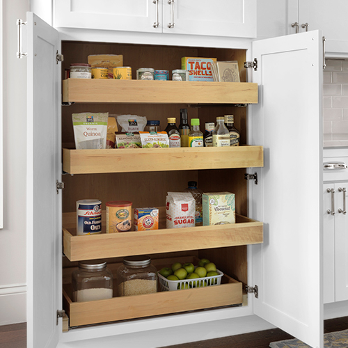 Tall painted white pantry cabinet with four maple wood roll out trays inside full of food