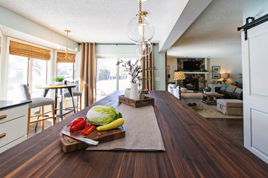 View of Kitchen dark wooden island top into the neighboring living room.