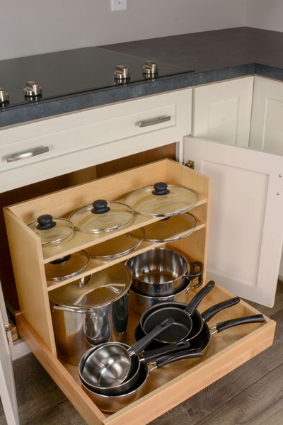 Pots and Pans pullout organizer, filled with pots and pans on the lowers roll out tray, and lids on the 2 shelves.